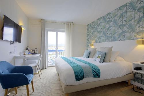 圣让-德吕兹乐莱斯圣雅克酒店的一间卧室配有一张床、一张书桌和一台电视。