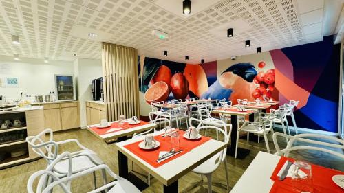 波尔多城市波尔多中央酒店的餐厅设有桌椅和色彩缤纷的墙壁