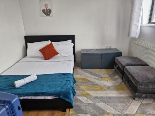 伦敦Immaculate 2-Bed Apartment in London的一间小卧室,配有一张床和一张边桌