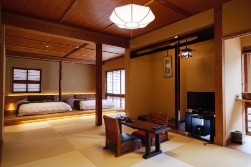 AtoichiArifuku Onsen Yoshidaya的一间卧室配有一张床和一张书桌