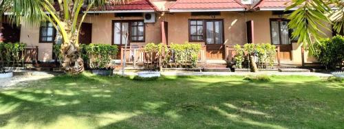 Derawan IslandsDerawan Beach Cafe and Cottage的前面有一座绿色庭院的房子