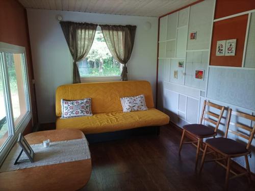 科克尼斯Namiņš Sidrabi pie upes的客厅配有橙色沙发和两把椅子