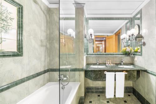 里斯本里斯波伯多禄酒店的浴室配有2个盥洗盆、浴缸和淋浴。
