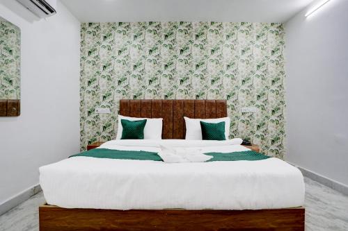 PrayagrajHotel Garden View的一间卧室配有一张带绿色和白色枕头的大床
