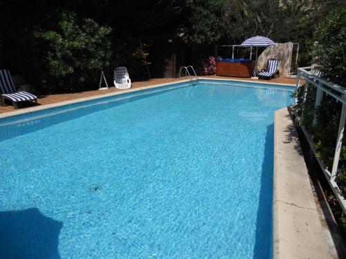 泰晤勒·苏尔·梅尔中庭酒店的一个带两把草坪椅的大型蓝色游泳池