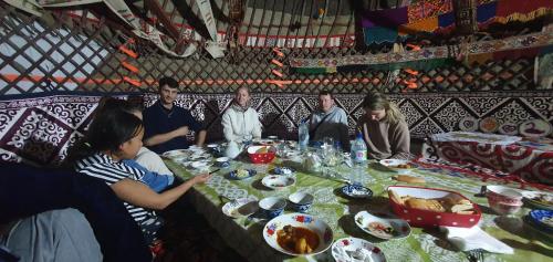 NurotaYurt Stay Family Khansar的一群人坐在桌子旁吃着食物