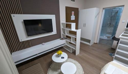 克拉多沃Apartmani Tomić的客厅配有电视和白色桌子