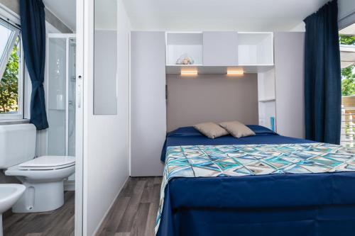 卡斯蒂里昂纳·德拉佩Camping Village Baia Azzurra Club的一间小卧室,配有一张床和一个卫生间
