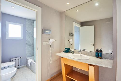 卡斯特利翁-德拉普拉纳Silken Turcosa的一间带水槽、卫生间和镜子的浴室