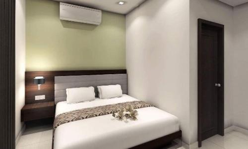 瓜廖尔Manara Event的一间卧室配有一张带白色床单的大床