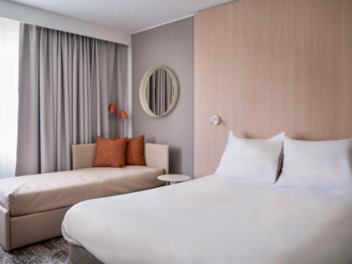 梅里尼亚克Novotel Bordeaux Mérignac的酒店客房,配有床和沙发