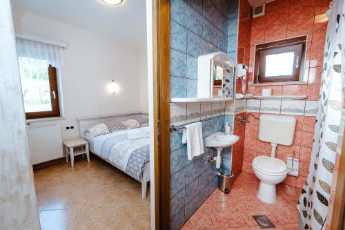 Miklavž pri OrmožuZelena Oaza - B&B的浴室设有床、卫生间和水槽。