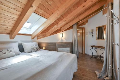 福森Chalet im Haus Schlossblick的卧室配有一张白色大床和天窗