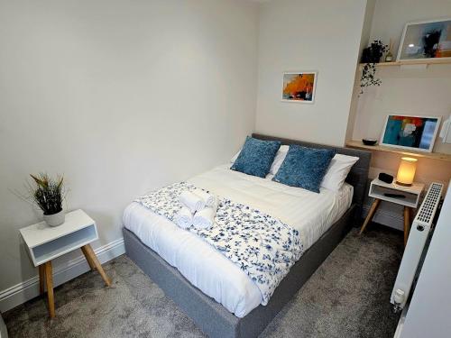 特尔福德Pass the Keys Flat 3 · Stylish Modern Apt with Patio的一间卧室配有一张带蓝色枕头的床
