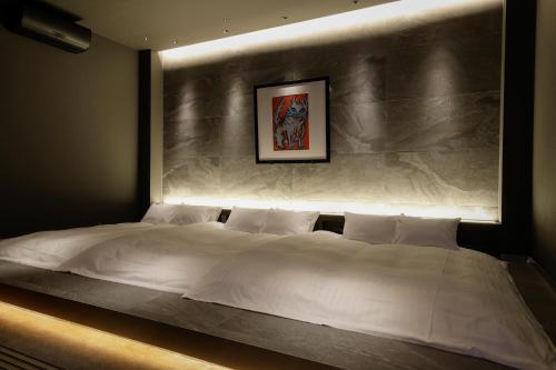 白滨FIVE SPRING RESORT THE SHIRAHAMA的卧室配有一张白色大床和墙壁