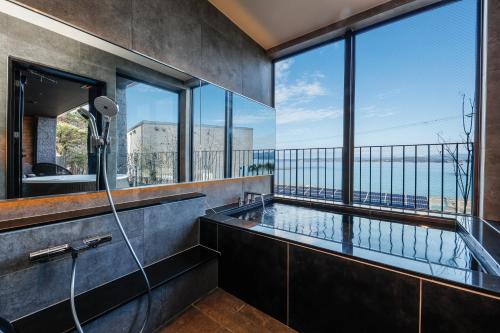 白滨FIVE SPRING RESORT THE SHIRAHAMA的带淋浴的浴室和大窗户