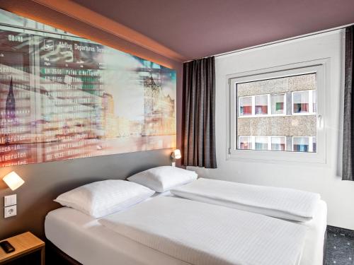 汉堡B&B Hotel Hamburg-Airport的一间卧室设有两张床,墙上挂着一幅画