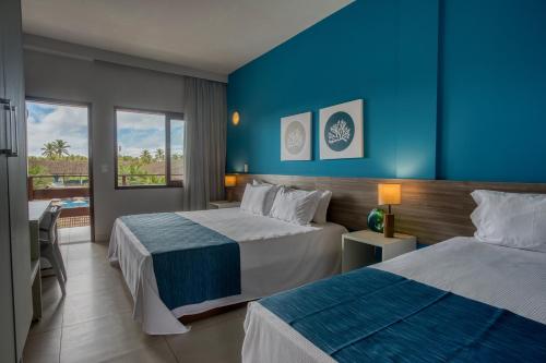 嘎林海斯港塔堡比智能酒店的酒店客房设有两张床和蓝色的墙壁。