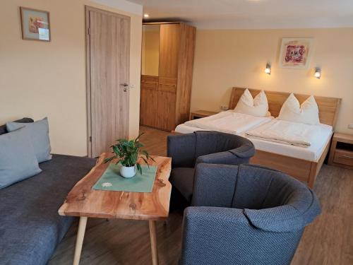 希格斯多夫Hotel Garni Edelweiß的酒店客房配有一张床、两把椅子和一张桌子