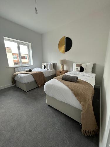 Free Parking! Comfy home in Barwell, Leicester -b-的一间卧室设有两张床和窗户。