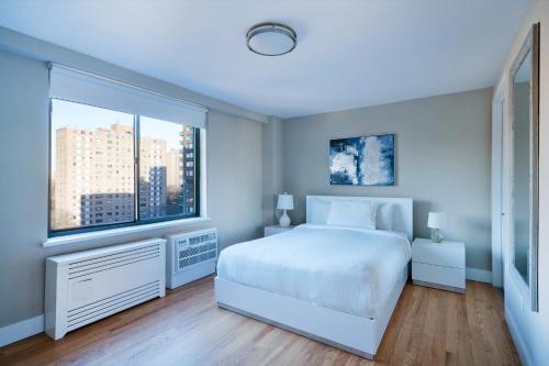 纽约Luxurious 2 BR Apartment with Private Balcony的卧室设有白色的床和大窗户