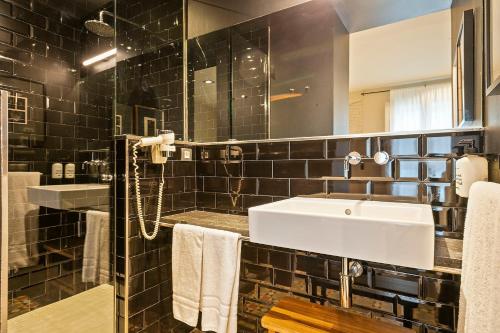 巴塞罗那Uma Suites Pau Claris的一间带水槽和镜子的浴室