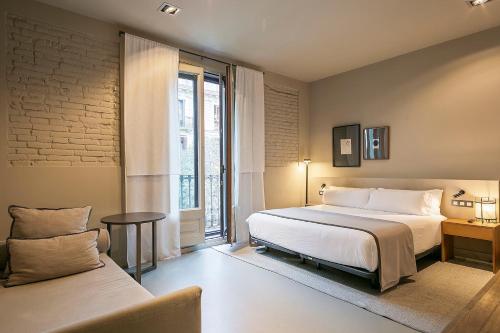 巴塞罗那Uma Suites Pau Claris的一间卧室设有一张大床和一个窗户。
