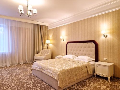 哈尔科夫Hotel Misto SPA & FITNESS的一间卧室配有一张大床和一把椅子