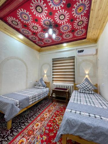 希瓦Khiva Rajab Ota的客房设有两张床和红色天花板。