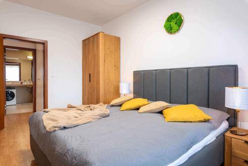多纳瓦利Apartmanica Residence 511的一间卧室配有一张带黄色枕头的大床