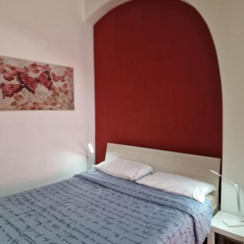 利沃诺Casa Fortunata con parcheggio的卧室配有一张床,墙上挂有绘画作品