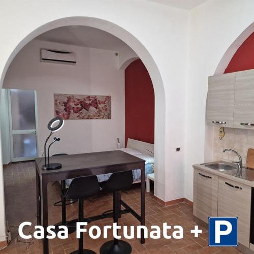利沃诺Casa Fortunata con parcheggio的厨房配有带台灯的桌子