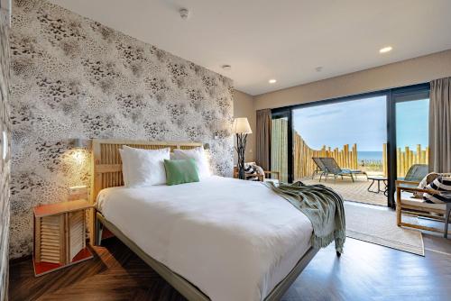 赞德沃特海滨别墅酒店的一间带大床的卧室和一个阳台
