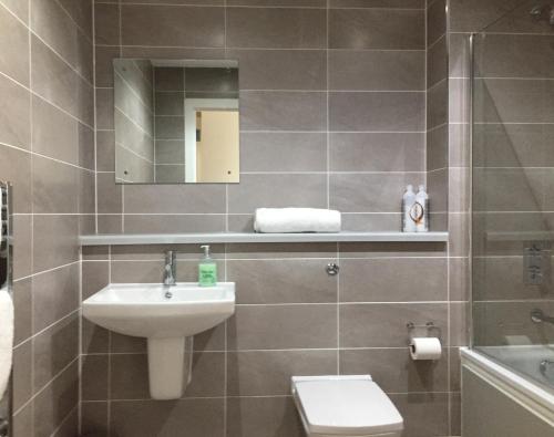 曼彻斯特Media City Salford Quays的一间带水槽、卫生间和镜子的浴室
