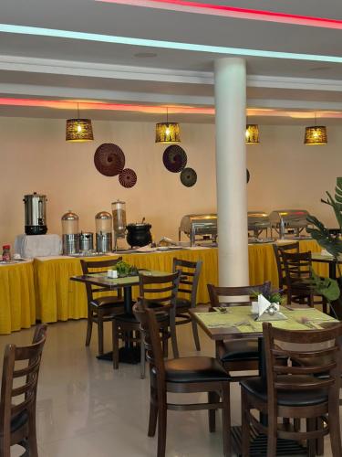 朱巴Aron International Hotel的一间带桌椅的用餐室和一间厨房