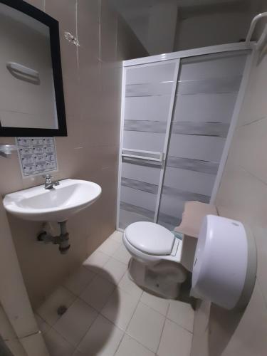 圣玛尔塔Rivera Hostel的白色的浴室设有卫生间和水槽。