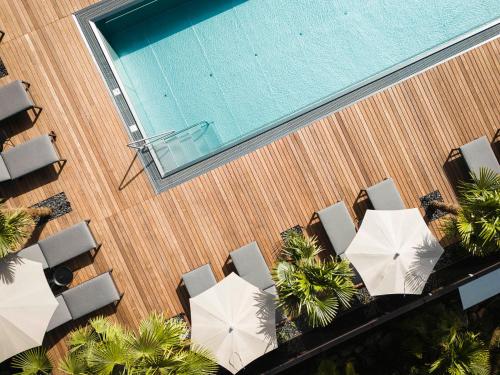拉古多Hotel Kassian的享有带椅子和遮阳伞的游泳池的上方景致