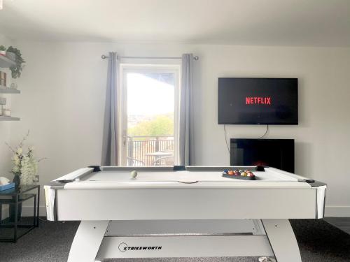 迪斯伯里Luxury Apartment with Balcony的客厅设有一张台球桌,配有电视。