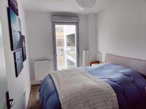 里尔Appartement 2 chambres Lille - proche du métro的一间卧室设有一张床和一个窗口