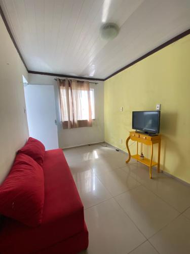费拉迪圣安娜Hoje Apartamentos的客厅配有红色沙发和电视