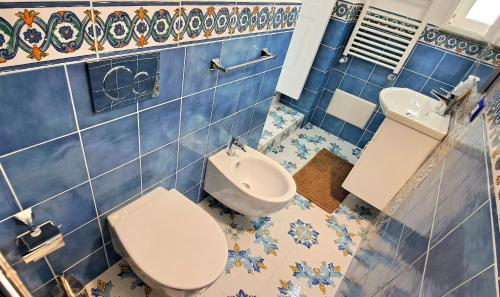 康加德马里尼Relais Amalfi Coast的蓝色瓷砖浴室设有卫生间和水槽