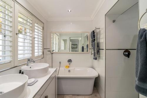 克尼斯纳One on Bollard的白色的浴室设有两个盥洗盆和镜子