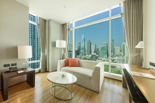 曼谷曼谷易思廷大酒店沙吞的带沙发和大窗户的客厅