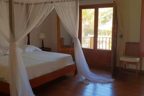 斯基灵角Ocean Lodge Resort的卧室配有带白色窗帘的床和窗户。