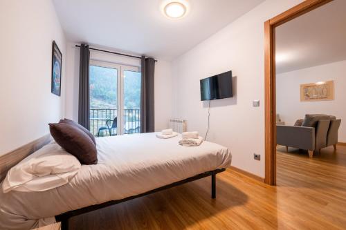 阿林萨尔Apartamento TINTIN en Arinsal的一间卧室设有一张床和一个大窗户