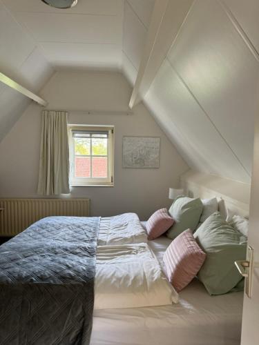 EibergenBed&Breakfast hotel de Greune Weide的卧室配有带枕头的床铺和窗户。