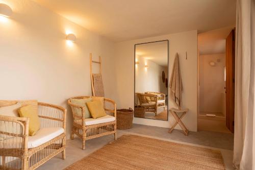 圣何塞Boutique Hotel Jardines de Palerm的客厅配有藤椅和镜子