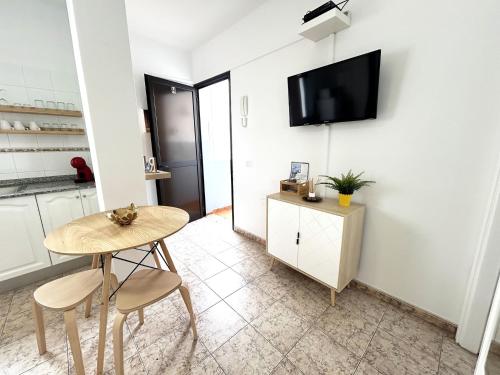 阿雷西费Mahostly Apartamento Comillas SH的客厅配有桌子,墙上配有电视