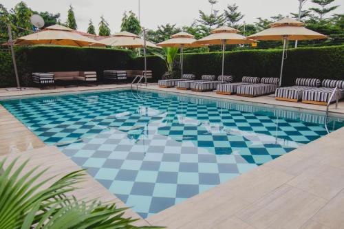 阿布贾BON Hotel Imperial的一个带椅子和遮阳伞的游泳池