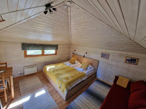 尤卡斯耶尔维Reindeer Lodge的木制客房内的一间卧室,配有一张床